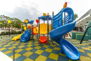 a playground with a slide in a park at Hotel Riviera in Mamaia