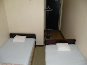 Postel nebo postele na pokoji v ubytování Business Hotel Minshuku Minato
