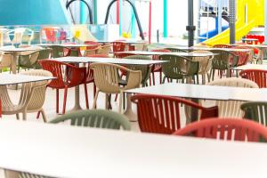 a group of tables and chairs in a cafeteria at Hotel Riviera in Mamaia