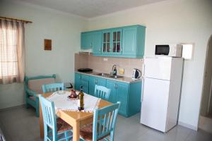 uma cozinha com uma mesa e um frigorífico branco em Liviko View em Xerokampos