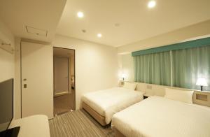 سرير أو أسرّة في غرفة في Sotetsu Fresa Inn Ginza Sanchome
