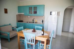 a kitchen with blue cabinets and a table and chairs at Liviko View in Xerokampos