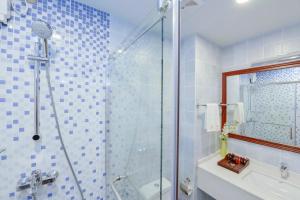 a bathroom with a shower and a toilet and a sink at Season Paradise in Thulusdhoo