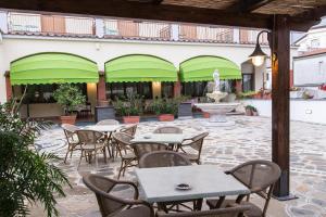 un patio al aire libre con mesas, sillas y una fuente. en Hotel Reginella, en SantʼAgata sui Due Golfi