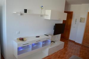 een woonkamer met een witte dressoir met blauwe verlichting bij VV Sarmiento in Vecindario