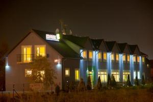 a large building with lights on at night at Hotel Wena in Kielce