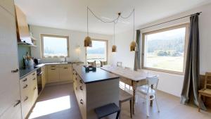 a kitchen with a table and a large window at Bellaval in Celerina
