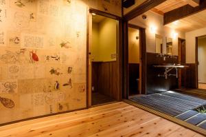 a bathroom with a wall with drawings on it at 一棟まるまる貸切宿 10名様まで Guesthouse Gokurakudo in Kyoto +140 photos