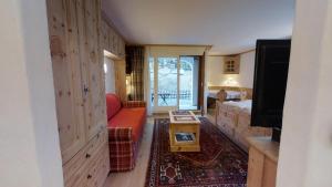 ein Wohnzimmer mit einem Sofa, einem Bett und einem TV in der Unterkunft Guardalej 205 in Champfer