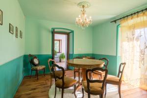 a dining room with a table and chairs and a chandelier at Chambres d'Hotes Quart de Lune in Quart