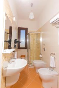 a bathroom with two sinks and a shower and a toilet at Villa Elios Guesthouse in Birgi Vecchi