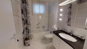 ein weißes Badezimmer mit Waschbecken und Toilette in der Unterkunft Paravicini in St. Moritz + 19 Fotos