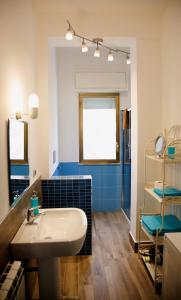 ein Badezimmer mit einem weißen Waschbecken und blauen Fliesen in der Unterkunft Siciliaiu in Mondello