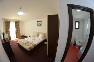 a hotel room with a bed and a mirror at Razvan Holiday in Costinesti