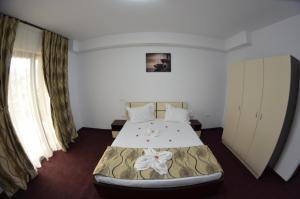 1 dormitorio con 1 cama en una habitación con cortinas en Razvan Holiday, en Costinesti
