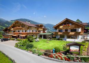 ein großes Haus mit Rasen davor in der Unterkunft Hotel Garni Larcherhof in Mayrhofen