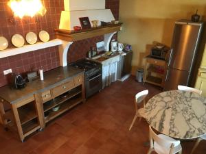 a kitchen with a table and a stove top oven at La Maison des Couleurs in Saint-Saturnin-lès-Apt