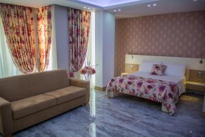 a hotel room with a bed and a couch at Hotel Vila Koral in Durrës