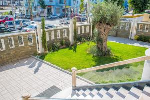 a tree in a yard next to a fence at Hotel Vila Koral in Durrës