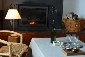 a table with a bottle of wine and glasses on it at Le chalet de Valentine in Ventron