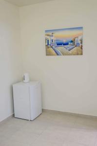 una nevera en una habitación con una foto en la pared en Maestro Apartments Faliraki en Faliraki