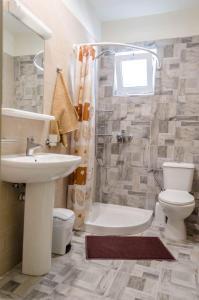 een badkamer met een wastafel, een toilet en een douche bij Maestro Apartments Faliraki in Faliraki