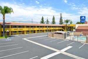 an empty parking lot in front of a yellow building at Americas Best Value Inn - Azusa/Pasadena in Azusa