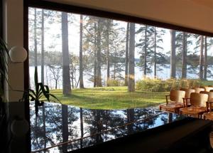 Cette chambre dispose d'une grande fenêtre offrant une vue sur la forêt. dans l'établissement Art Hotel Honkahovi, à Mänttä