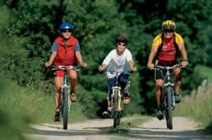 three people riding bikes down a dirt road at Landgasthof Kirchenwirt in Grossraming