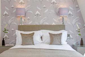 a bedroom with a bed with two purple lamps at Chesham Court Knightsbridge in London