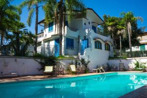 a house and a swimming pool in front of a house at Baia D'Oro in Sabaudia