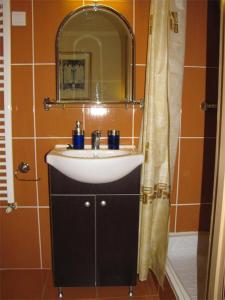 een badkamer met een wastafel en een spiegel bij Pávai Vendégház in Hajdúszoboszló
