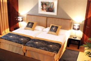 een slaapkamer met een groot bed met 2 kussens bij Art Hotel Honkahovi in Mänttä