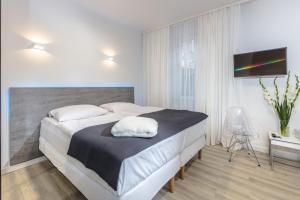 1 dormitorio con 1 cama grande y TV de pantalla plana en Villa Rosa - 200m od morza, en Międzyzdroje
