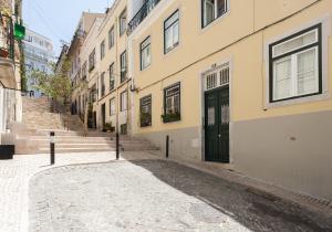 een lege straat met een gebouw met een zwarte deur bij FLH Bica Modern Flat with View in Lissabon