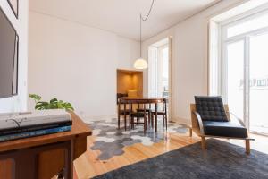 een woonkamer met een tv en een tafel en stoelen bij FLH Bica Modern Flat with View in Lissabon