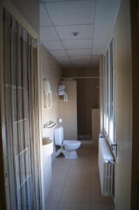 a bathroom with a toilet and a sink and a tub at Le Régence in Arles