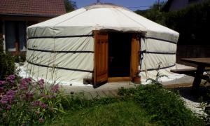 a yurt with a wooden door in a yard at yourte d'hotes in Mailley-et-Chazelot