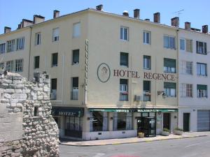 um hotel com uma placa que lê a reserva do hotel em Le Régence em Arles