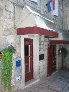 ein Gebäude mit einer roten Tür und einer Markise in der Unterkunft Apartment Paradiso in Split