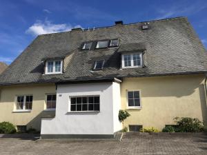 een groot wit huis met een grijs dak bij Sky in Winterberg