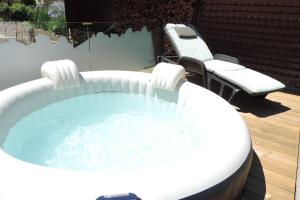 a hot tub on a patio with two chairs at B&B Casa Vanzetta in Ziano di Fiemme