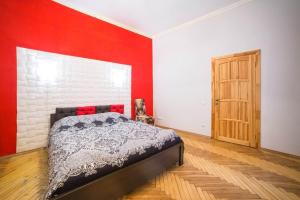 リヴィウにあるApartment on Krakivska 26の赤い壁のベッドルーム1室(ベッド1台付)
