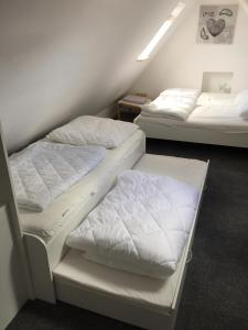 twee bedden in een kamer met witte lakens bij Sky in Winterberg