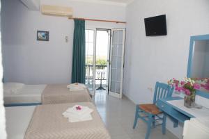 a hotel room with two beds and a desk and a balcony at Liviko View in Xerokampos +44 photos