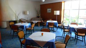 ein Esszimmer mit Tischen, Stühlen und einem Fenster in der Unterkunft Hotel Meran Hallenbad & Sauna in Saarbrücken