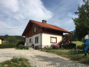 kobieta stojąca przed domem w obiekcie Apartment in St. Jakob im Rosental w mieście Sankt Jakob im Rosental