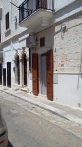 a building with wooden doors on the side of a street at GIUAMAR casa vacanza in Polignano a Mare