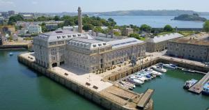 an aerial view of a building with boats in a harbor at Drakes Wharf @ Royal William Yard in Plymouth