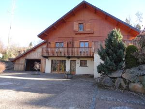 a large wooden house with a balcony at Chalet la roche du rain in Gérardmer